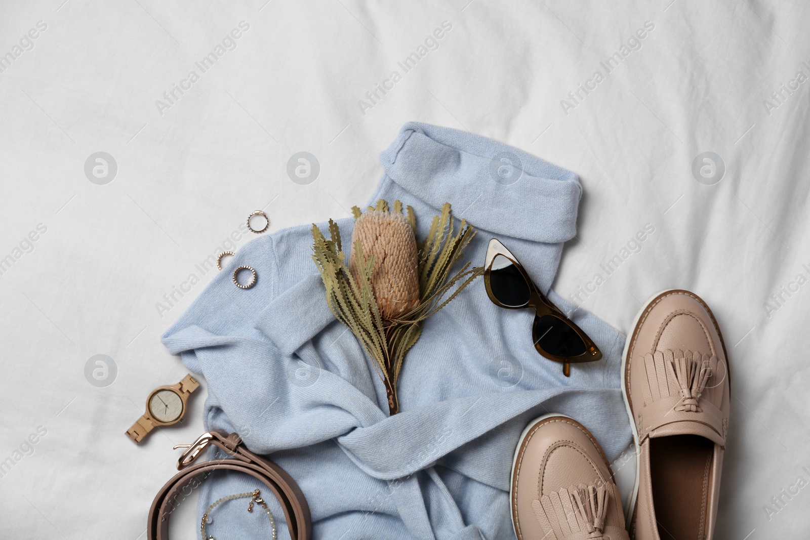 Photo of Stylish look with cashmere sweater, flat lay. Women's clothes and accessories on fabric