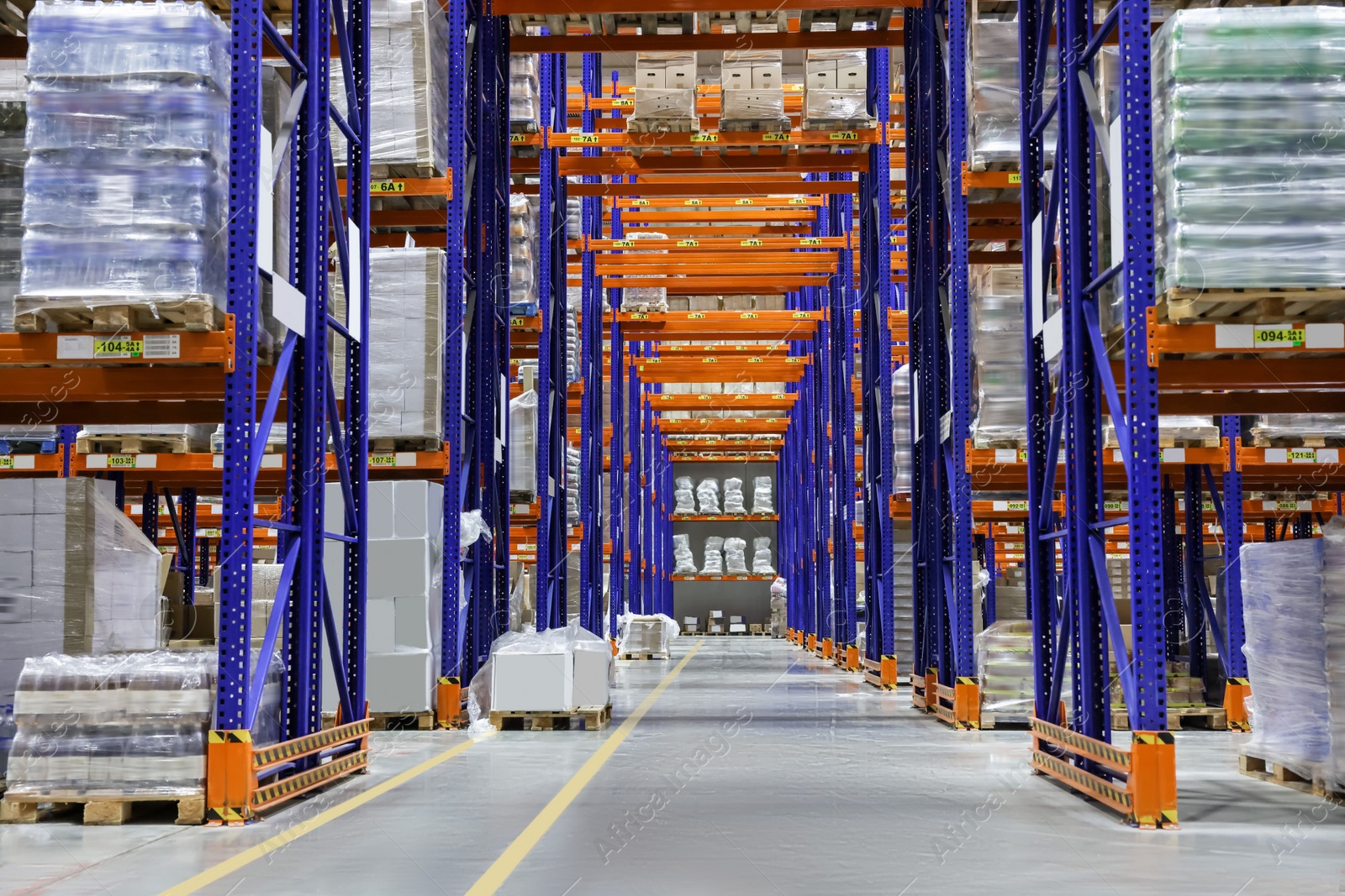 Photo of Warehouse interior with metal racks full of merchandise. Wholesale business