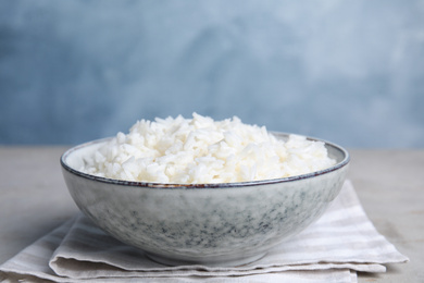 Photo of Bowl with tasty cooked rice on table, closeup