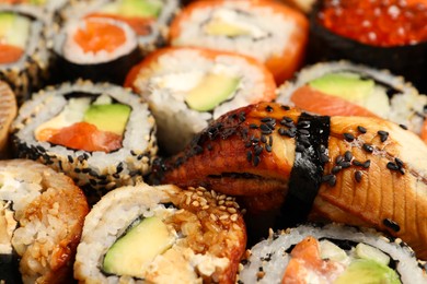 Different tasty sushi rolls as background, closeup