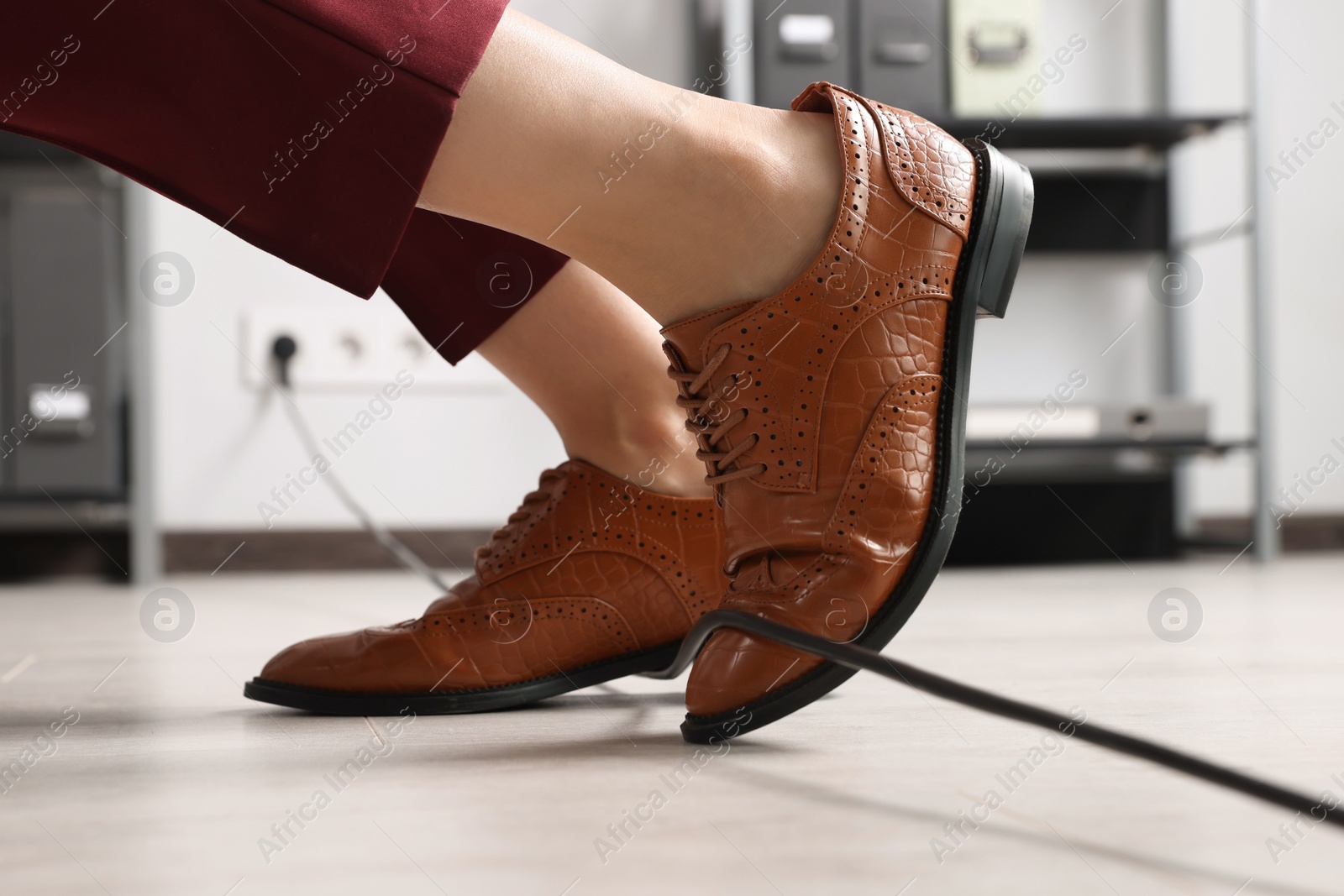 Photo of Woman tripping over cable in office, closeup