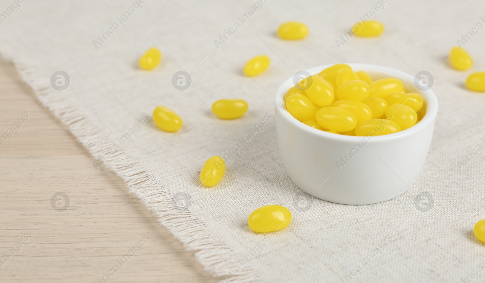 Photo of Many tasty lemon drops on wooden table