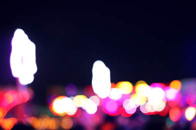 Photo of Blurred view of city street with festive lights at night. Bokeh effect