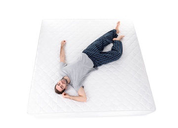 Young man sleeping on mattress against white background, above view