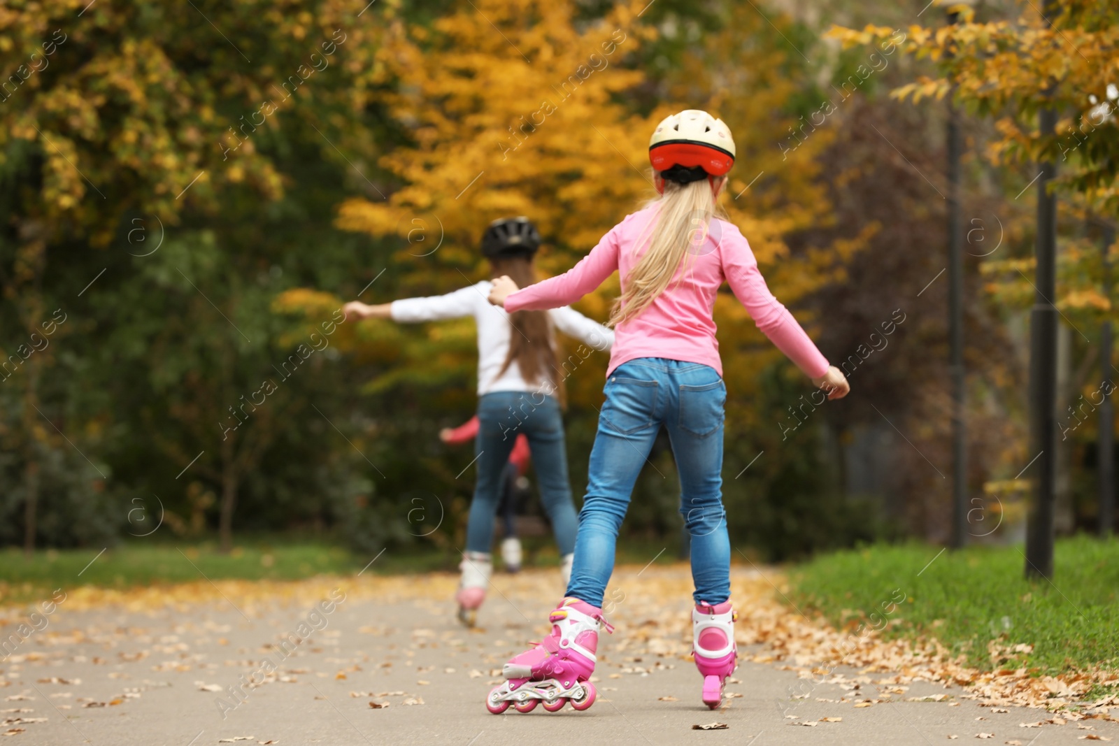 Photo of Cute children roller skating in autumn park