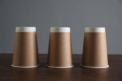 Photo of Shell game. Three paper cups on wooden table