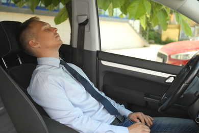 Photo of Tired young man sleeping in his modern car