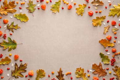 Photo of Frame of beautiful autumn leaves, physalis and berries on beige background, flat lay. Space for text