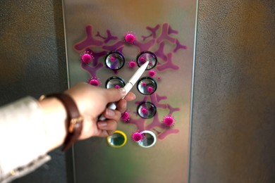 Image of Woman using pen press button in elevator with germs, closeup