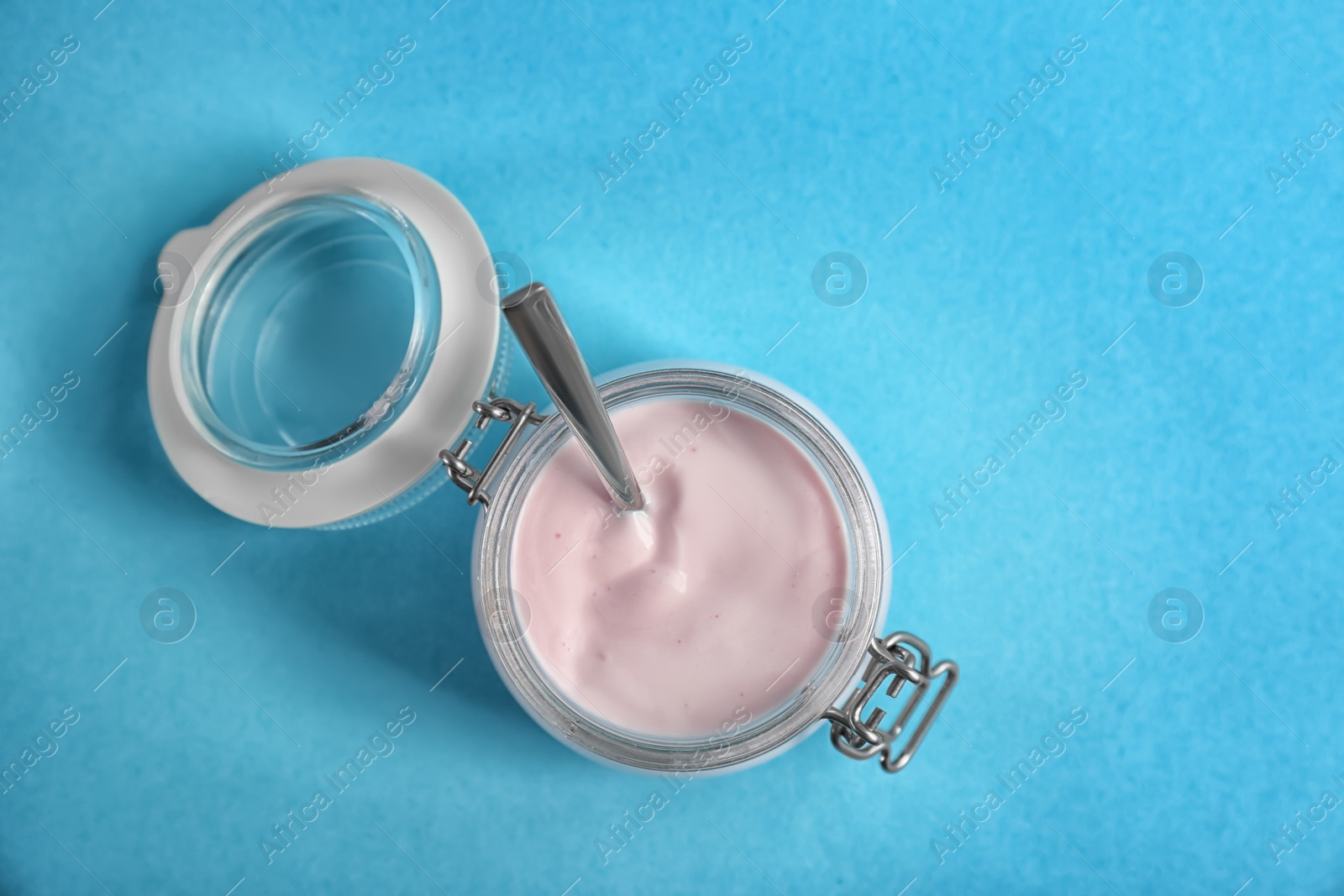 Photo of Jar with tasty yogurt on color background, top view