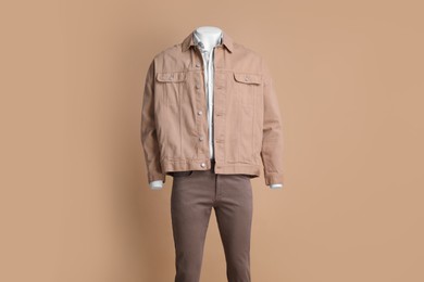 Photo of Male mannequin dressed in white shirt, jacket and pants on beige background