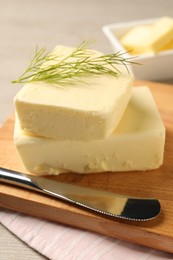 Photo of Tasty butter with dill and knife on wooden table, closeup