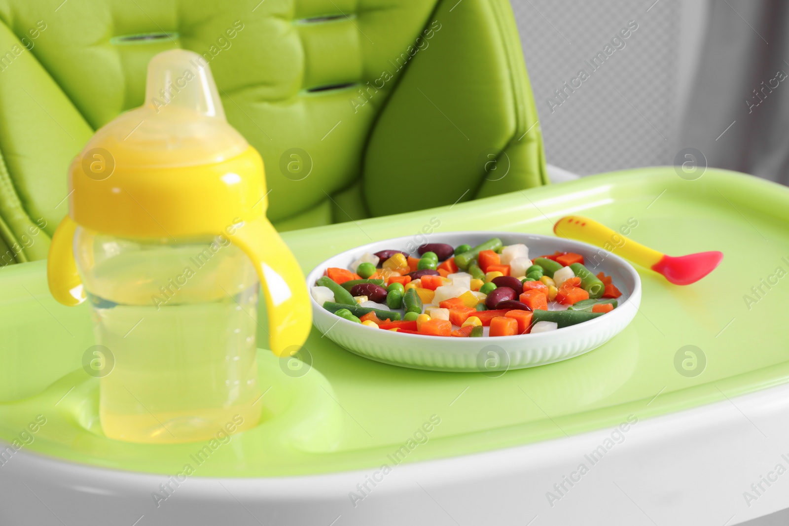 Photo of Baby high chair with healthy food and water, closeup view