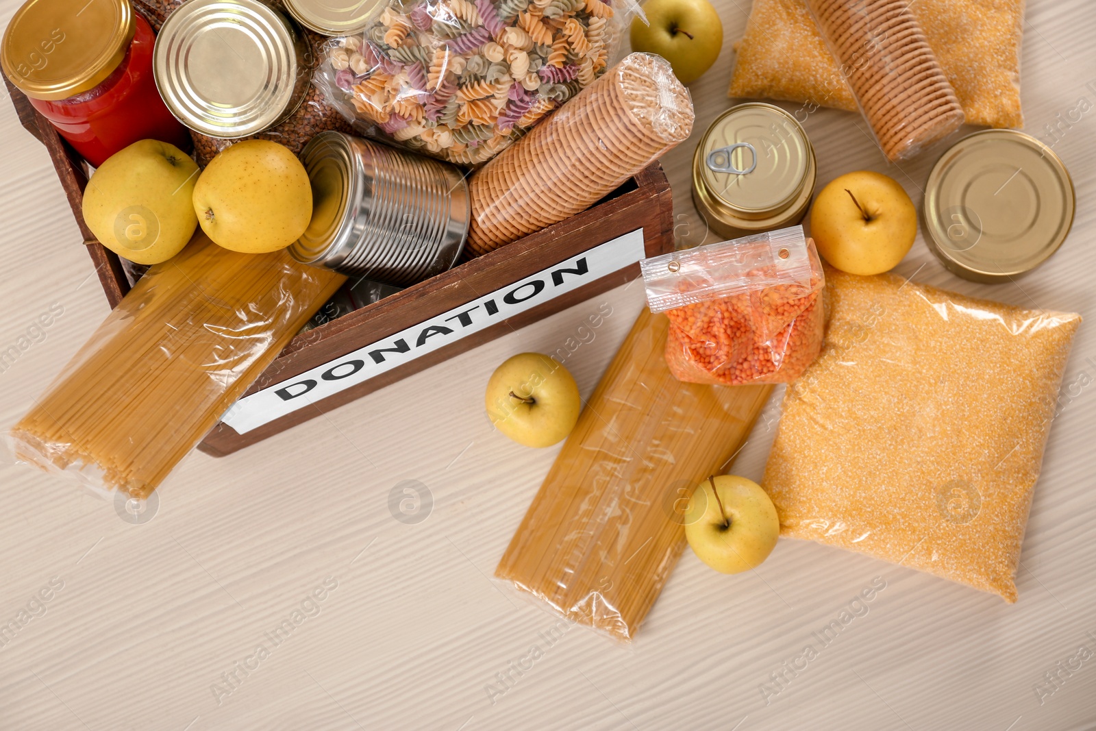 Photo of Donation box and different products on wooden table, top view