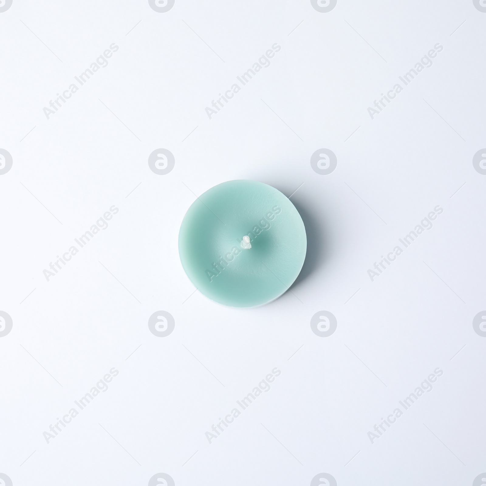 Photo of Light blue wax decorative candle isolated on white, top view