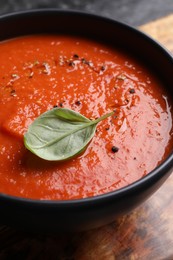 Photo of Delicious tomato cream soup in bowl on table, closeup