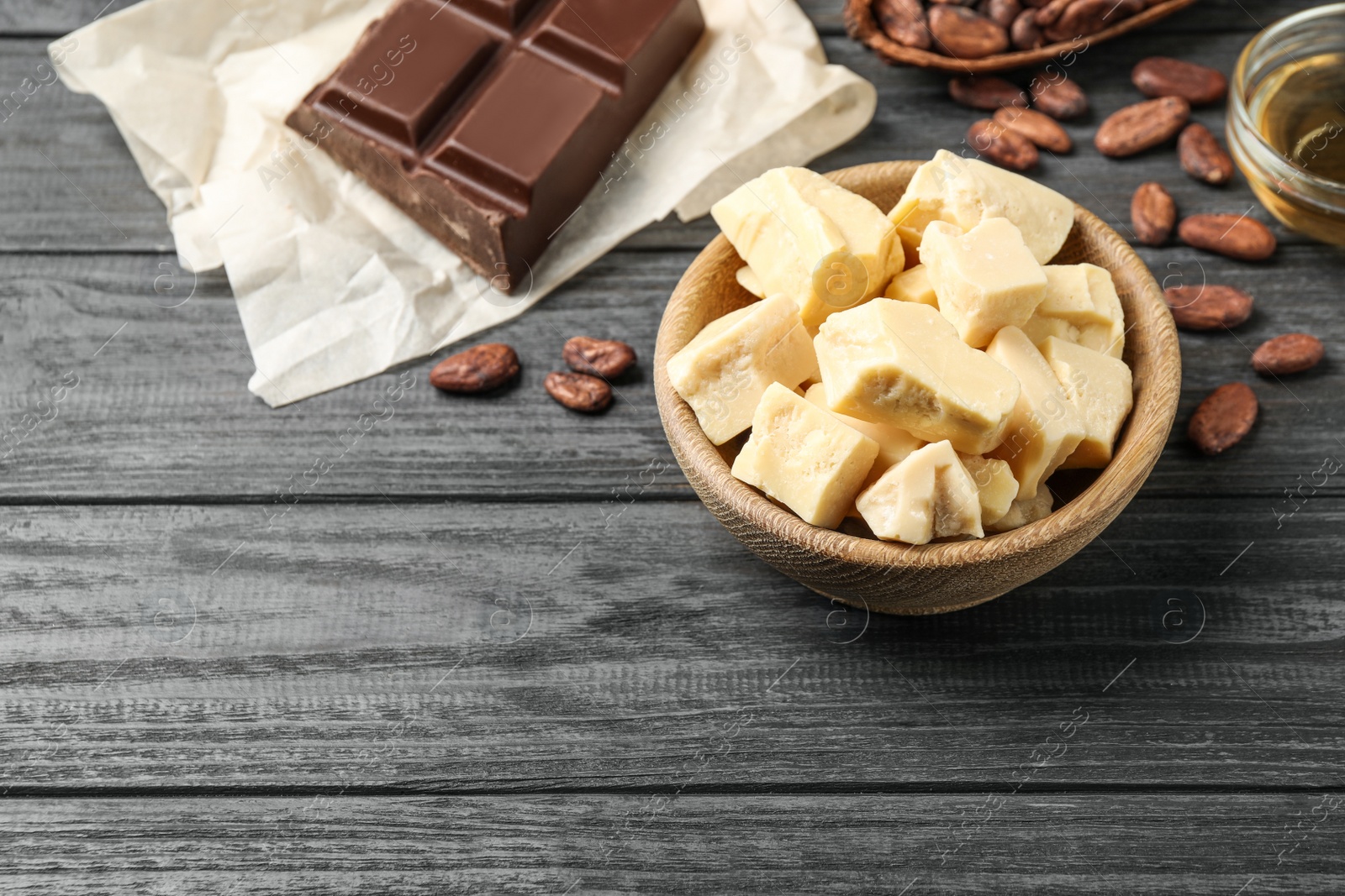 Photo of Composition with organic cocoa butter on black wooden table, above view. Space for text