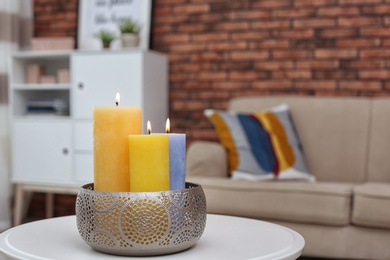 Photo of Burning candles on table indoors. Interior decor element