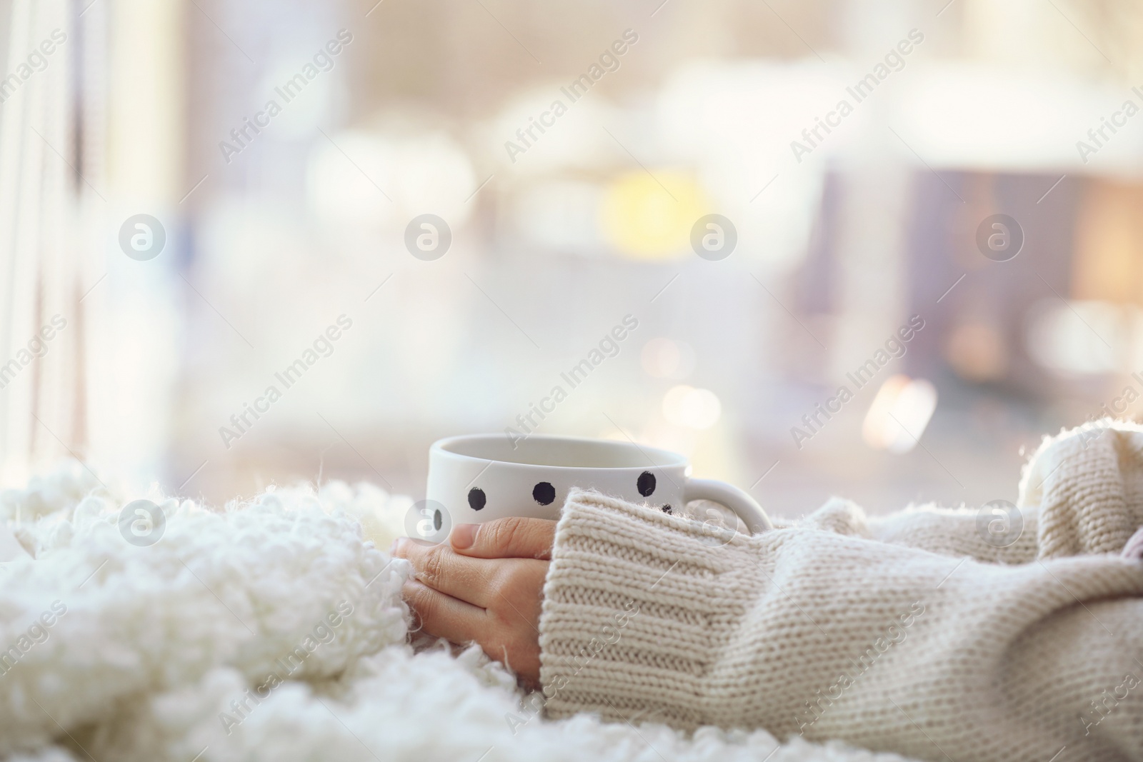 Photo of Woman with cup of coffee near window in morning, closeup. Space for text