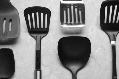 Photo of Different spatulas on grey marble table, flat lay