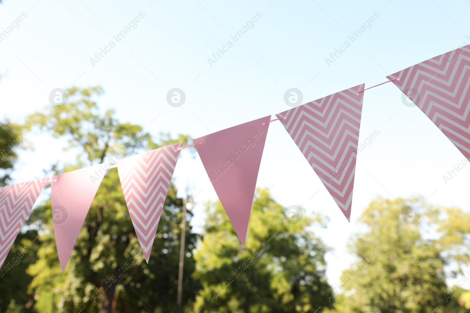 Photo of Pink bunting flags in park. Party decor