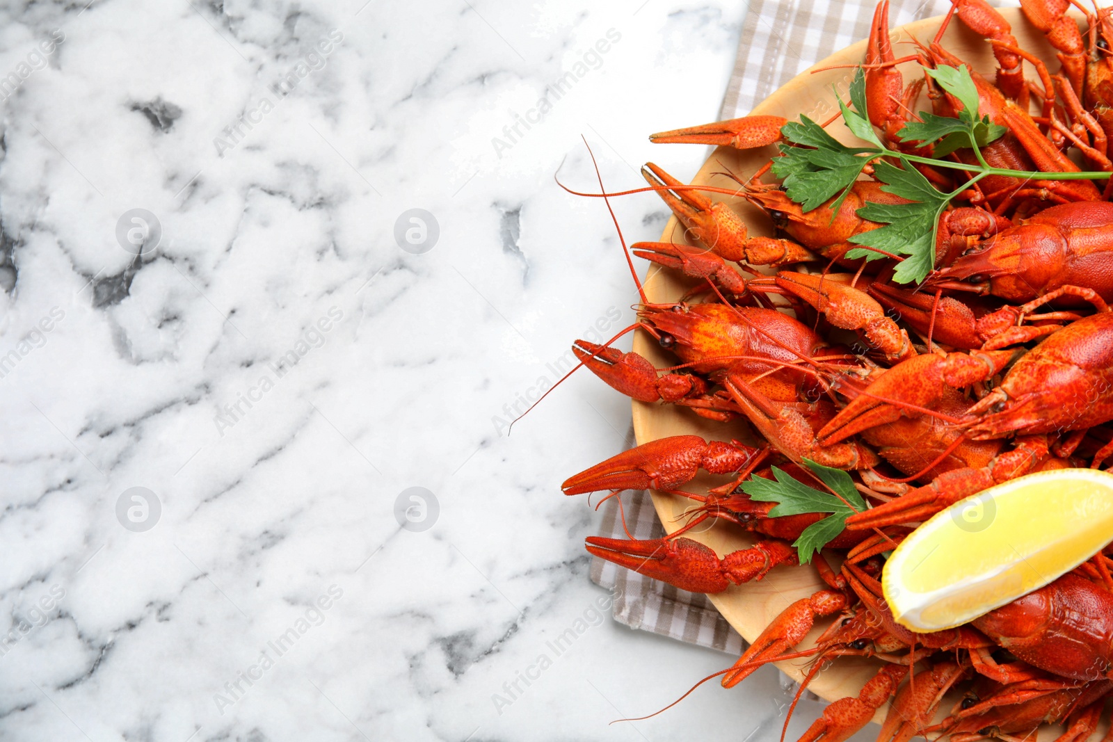 Photo of Delicious boiled crayfishes on white marble table, top view. Space for text