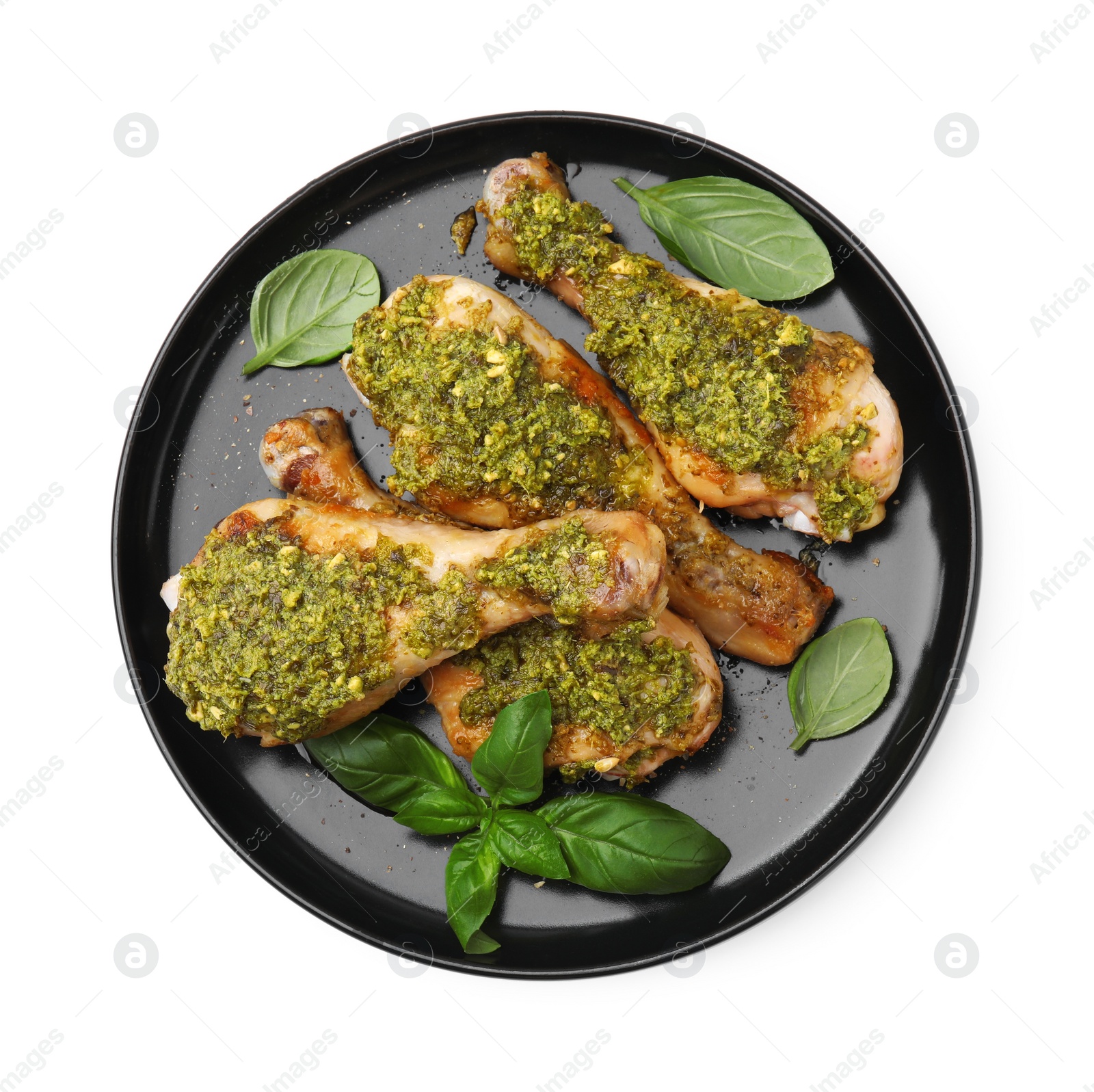 Photo of Delicious fried chicken drumsticks with pesto sauce and basil isolated on white, top view