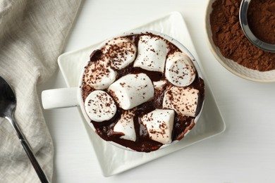 Photo of Delicious hot chocolate with marshmallows and cocoa powder in cup on white table, top view