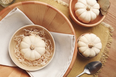 Autumn table setting with pumpkins and decor on yellow cloth, flat lay