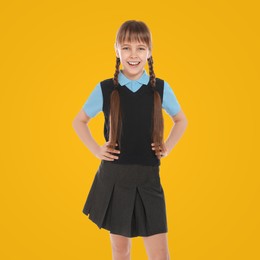 Image of Portrait of cute girl wearing school uniform on yellow background