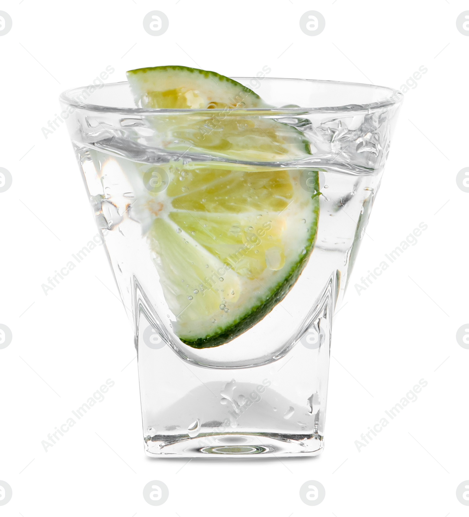 Photo of Vodka splashing out of shot glass with lime on white background