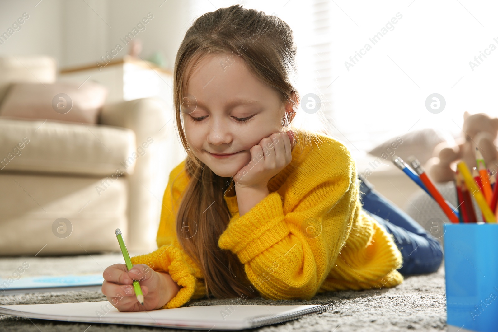 Photo of Little girl drawing on floor at home