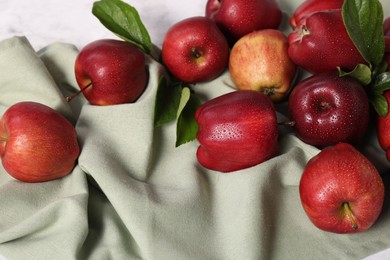 Photo of Ripe red apples with leaves and water drops on table