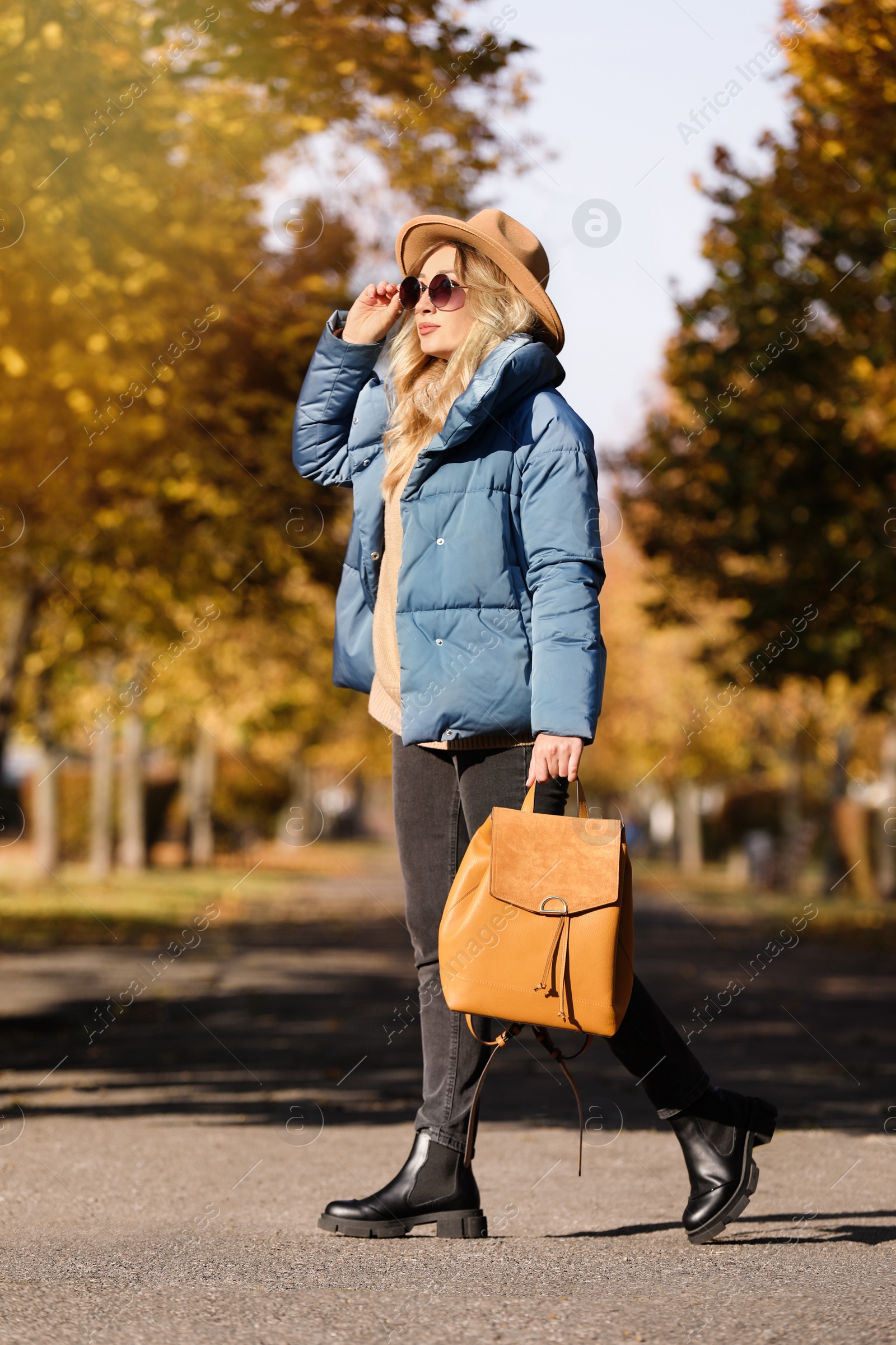 Photo of Young woman with stylish backpack on autumn day