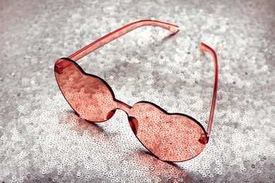 Photo of Pink heart shaped sunglasses on bright background