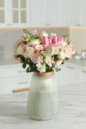 Photo of Beautiful bouquet of fresh flowers in vase on table indoors
