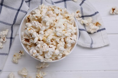 Photo of Tasty popcorn on white wooden table, flat lay