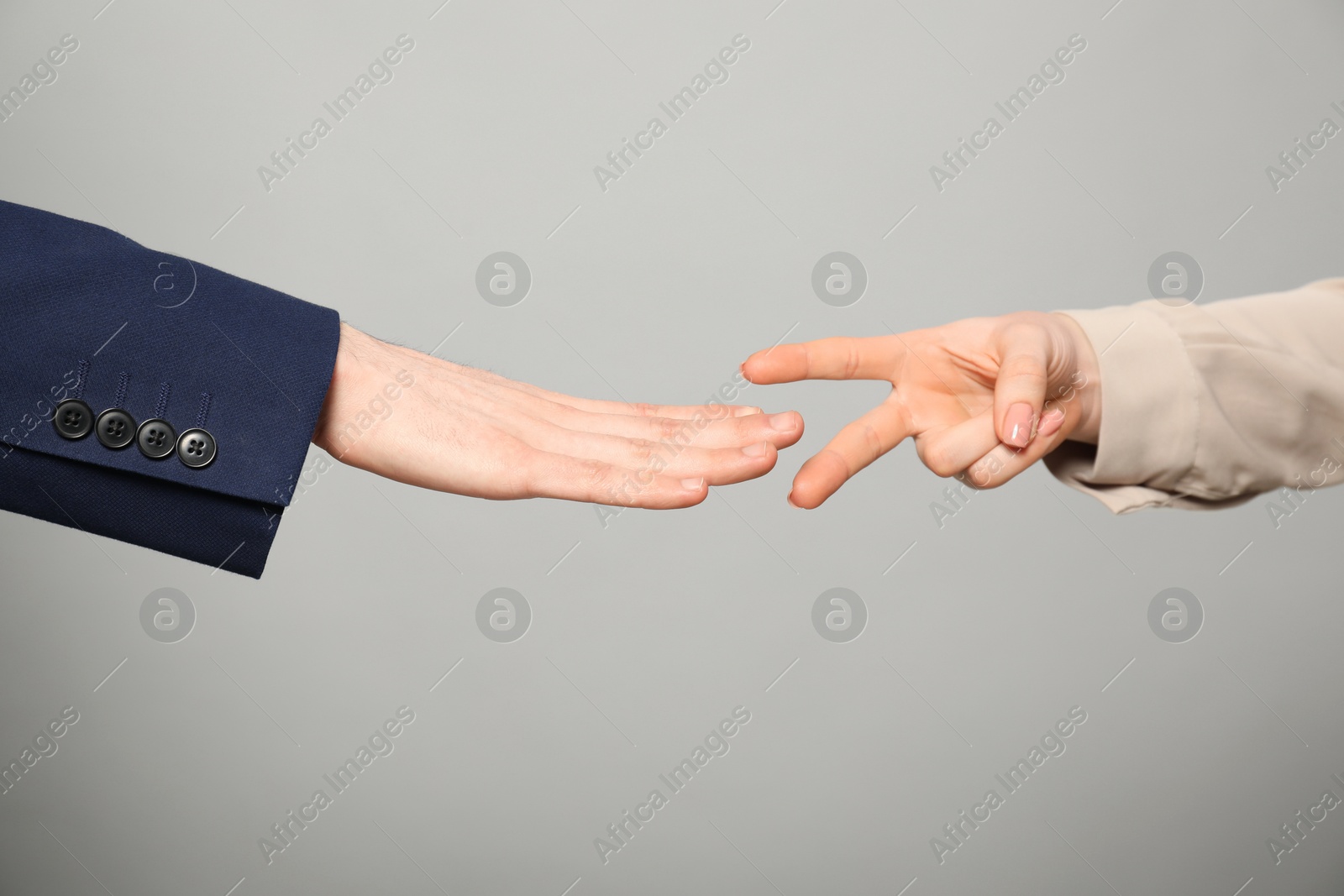 Photo of People playing rock, paper and scissors on grey background, closeup