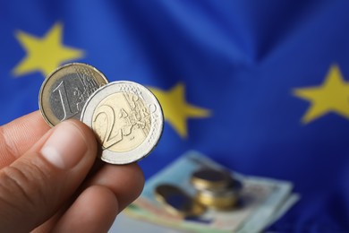 Photo of Woman holding coins near European Union flag, closeup. Space for text