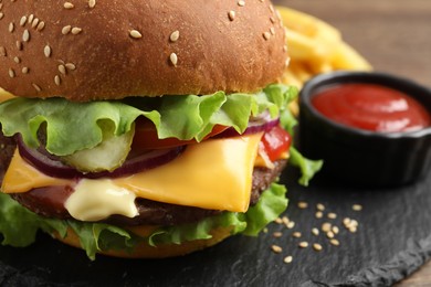 Photo of Delicious burger with beef patty and tomato sauce on dark board, closeup