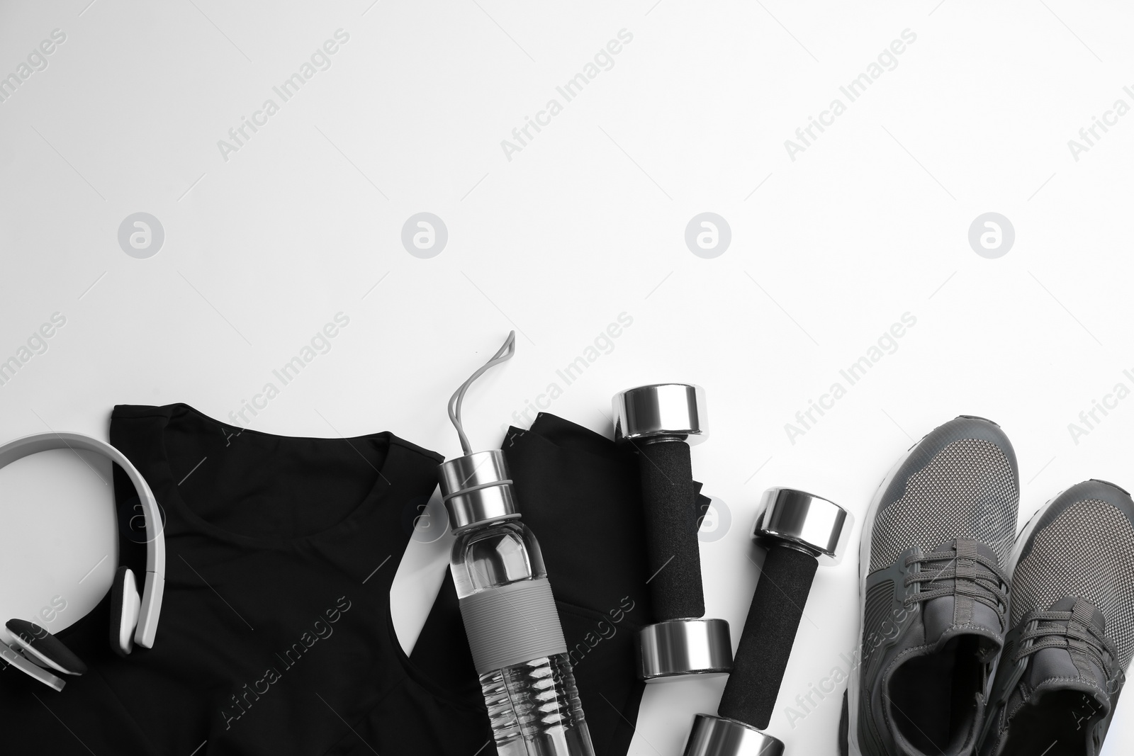 Photo of Flat lay composition with sportswear and dumbbells on white background, space for text. Gym workout