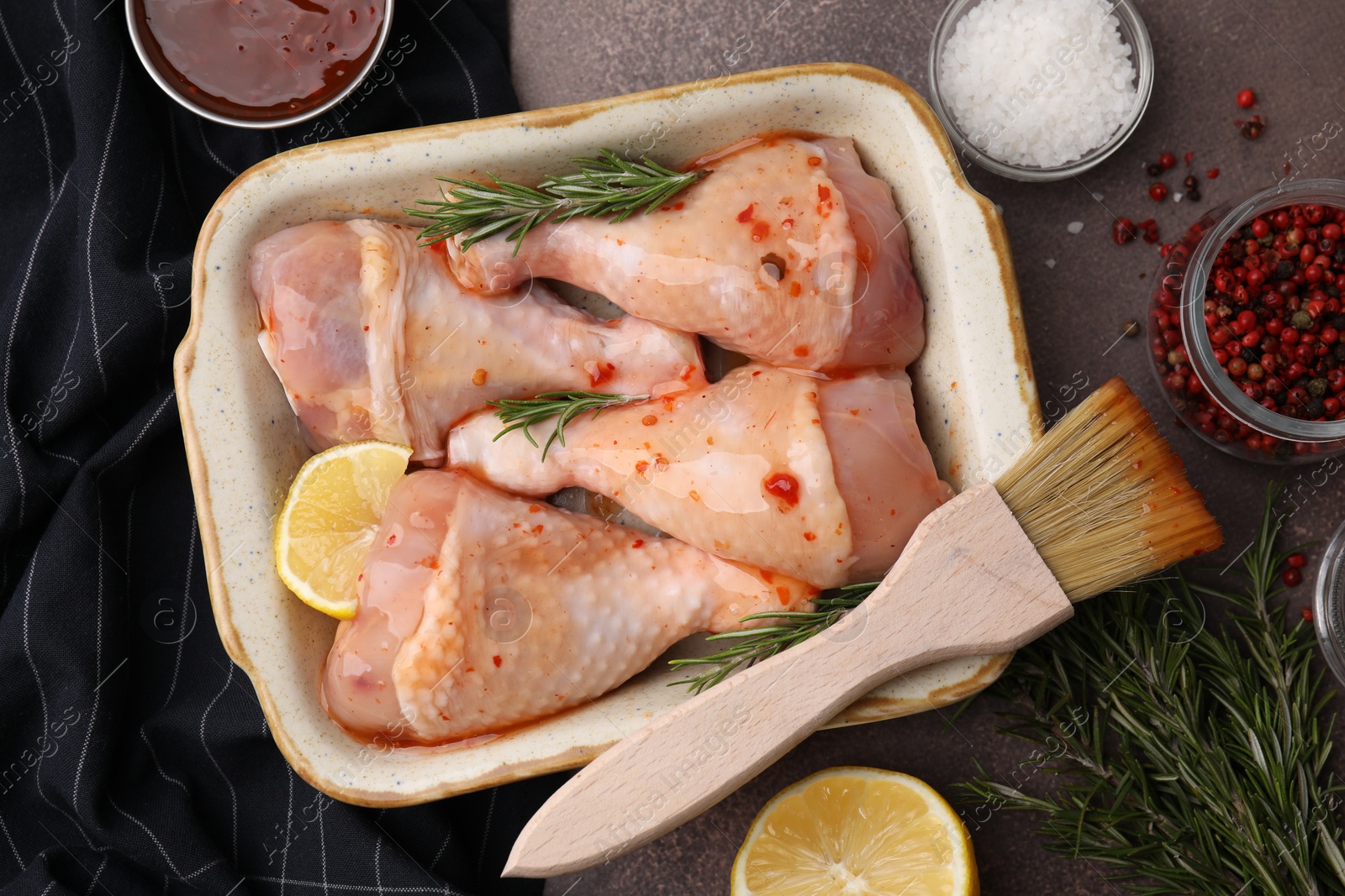 Photo of Flat lay composition with marinade and raw chicken drumsticks on brown table