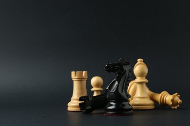 Photo of Different chess pieces on dark background. Space for text