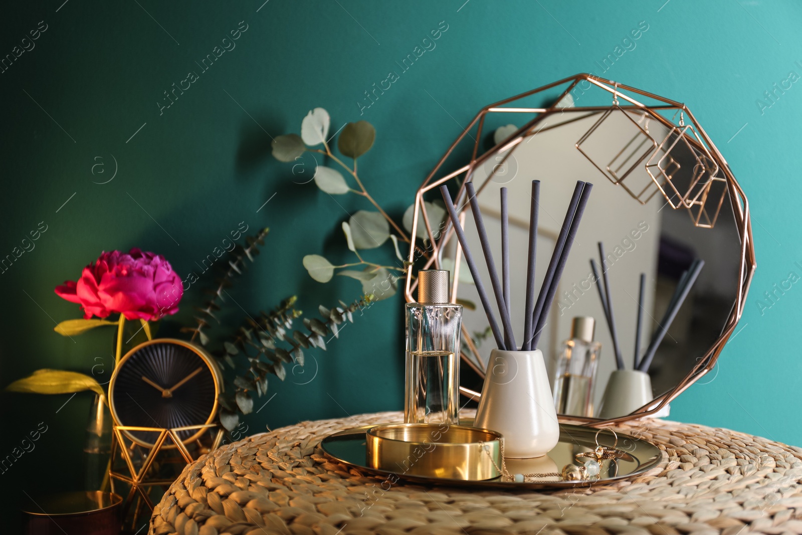 Photo of Composition with stylish accessories and interior elements on table near turquoise wall