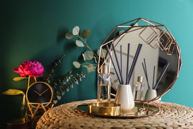 Composition with stylish accessories and interior elements on table near turquoise wall