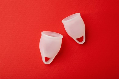 Photo of Menstrual cup on red background, flat lay