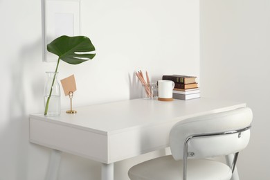 Comfortable workplace with white desk near wall at home