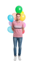 Young man holding bunch of colorful balloons on white background