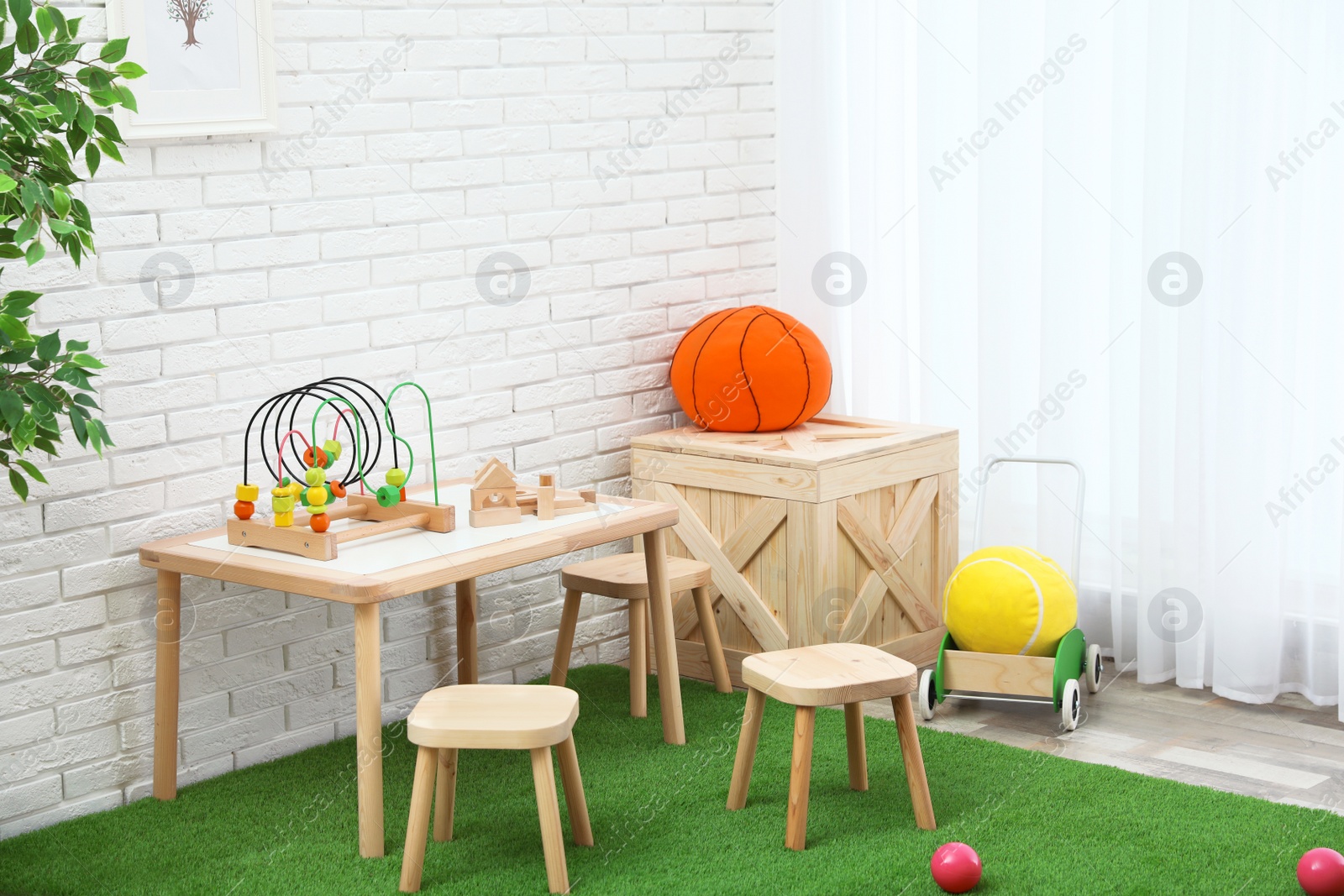 Photo of Stylish playroom interior with toys and modern wooden furniture