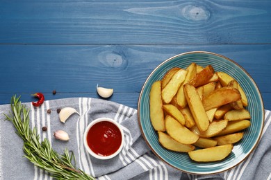 Photo of Flat lay composition with delicious baked potatoes, tomato sauce and rosemary on blue wooden table. Space for text